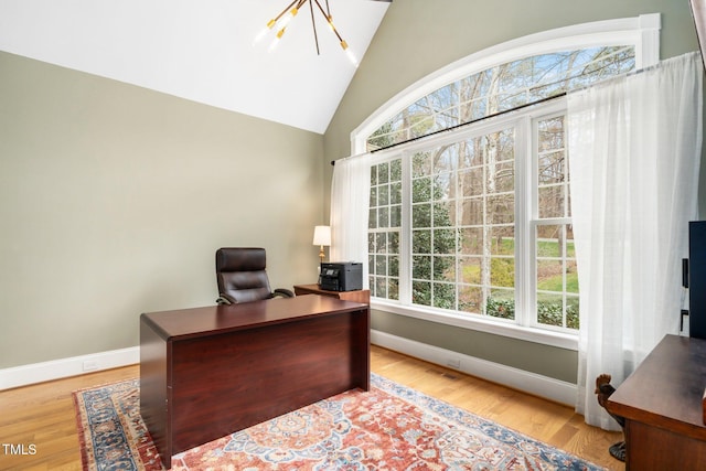 office space featuring plenty of natural light, wood finished floors, and vaulted ceiling