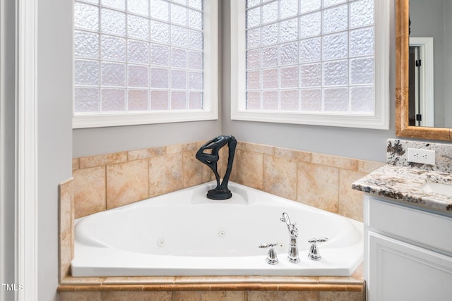 full bathroom featuring a whirlpool tub and vanity