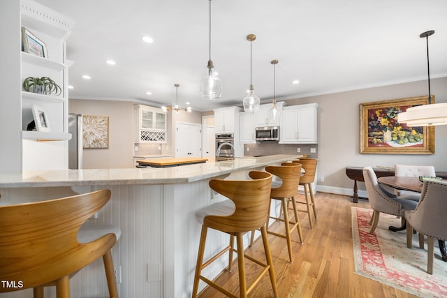 kitchen with backsplash, white cabinetry, stainless steel appliances, and crown molding