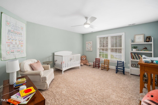 bedroom featuring baseboards, visible vents, carpet floors, ceiling fan, and a nursery area