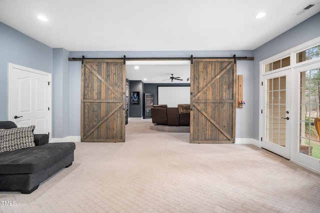 sitting room featuring visible vents, recessed lighting, a barn door, carpet floors, and baseboards