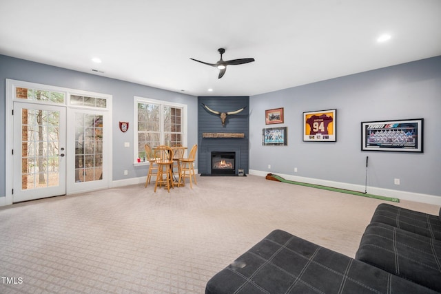 carpeted living room with recessed lighting, french doors, baseboards, and a large fireplace