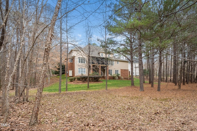 back of property featuring brick siding and a lawn