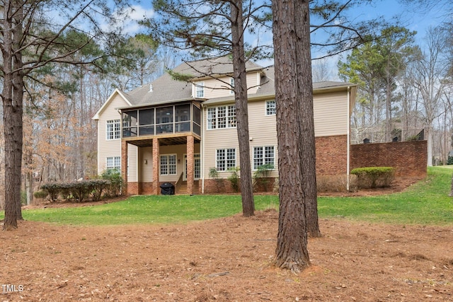 back of property with a yard and a sunroom