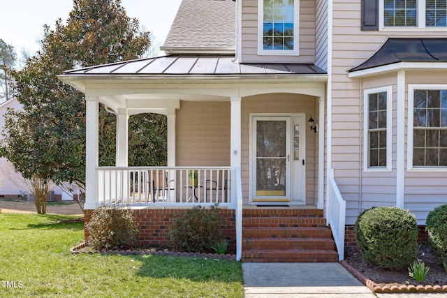 doorway to property with a standing seam roof, a shingled roof, metal roof, and a porch