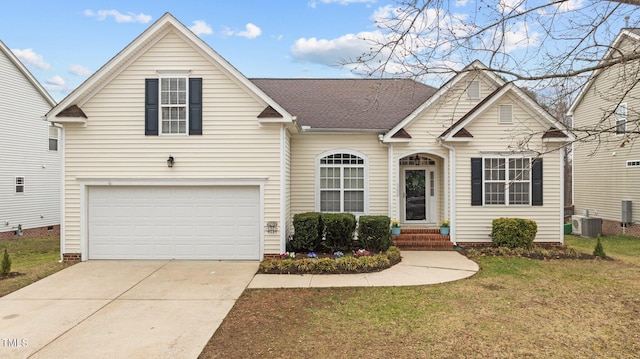 traditional-style house with a shingled roof, concrete driveway, central AC unit, a front yard, and a garage