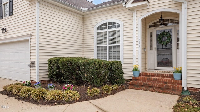 property entrance featuring roof with shingles and an attached garage