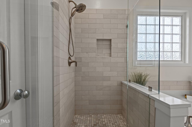 bathroom featuring tiled shower and a wealth of natural light