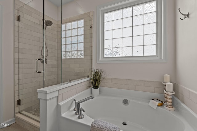 bathroom with a stall shower, plenty of natural light, and a bath