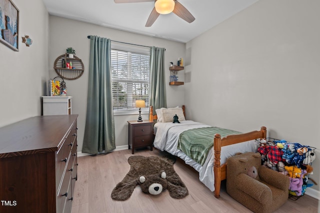 bedroom with a ceiling fan, light wood-type flooring, and baseboards