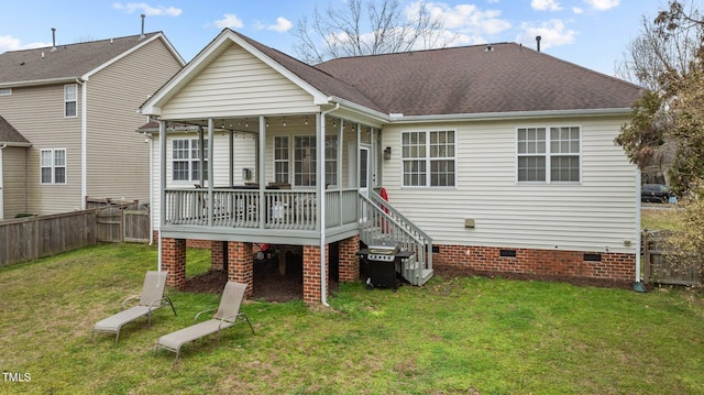 rear view of house featuring a yard, a shingled roof, a sunroom, crawl space, and fence