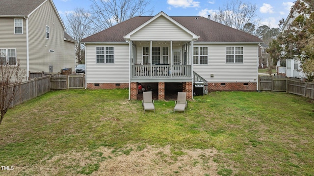 rear view of property with roof with shingles, crawl space, a fenced backyard, and a lawn