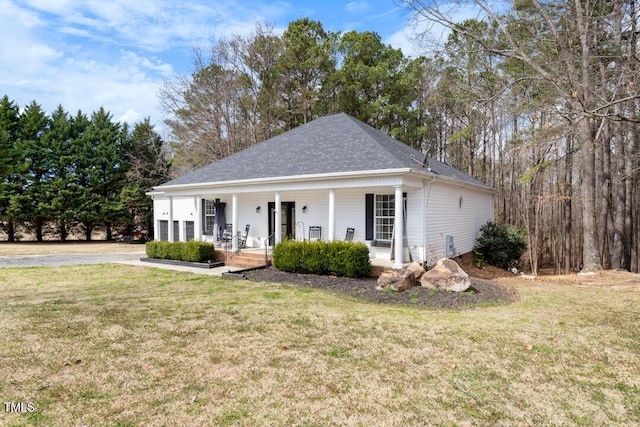 view of front of property with a porch, a garage, a shingled roof, and a front lawn