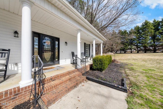 property entrance featuring covered porch and a yard