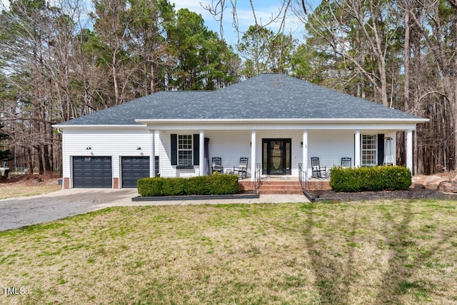 view of front facade with covered porch, a garage, driveway, roof with shingles, and a front lawn