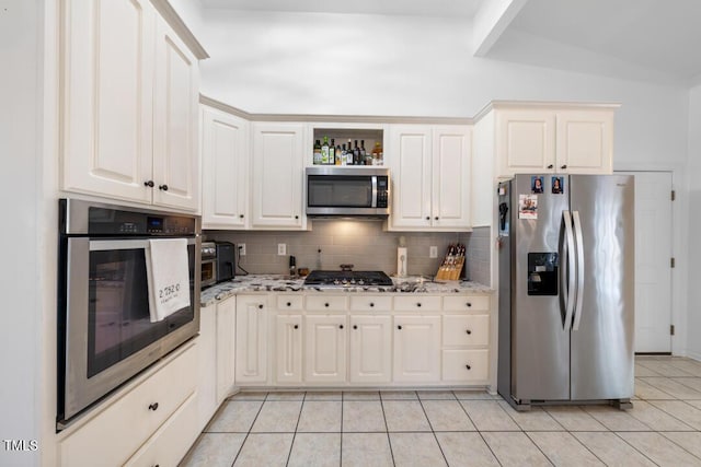 kitchen with light stone counters, light tile patterned flooring, stainless steel appliances, white cabinets, and tasteful backsplash