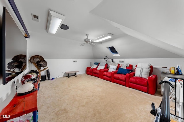 home theater room featuring vaulted ceiling with skylight, visible vents, ceiling fan, and carpet flooring