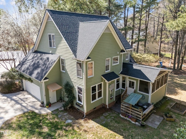 exterior space with a shingled roof, concrete driveway, a garage, a sunroom, and crawl space