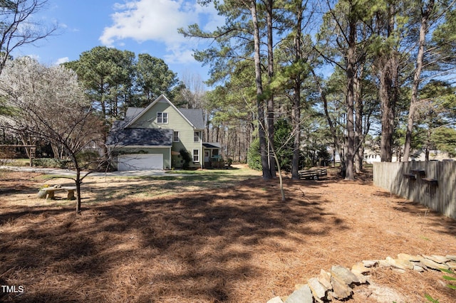 view of property exterior featuring a garage and fence