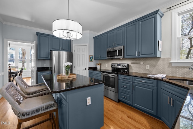 kitchen with stainless steel appliances, blue cabinets, and a sink