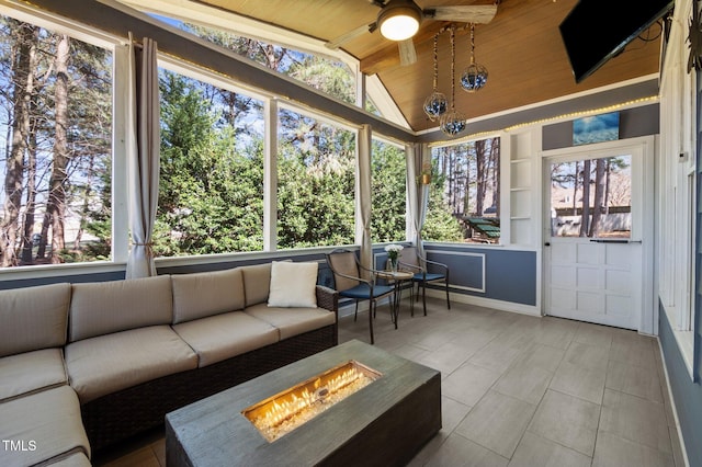 unfurnished sunroom featuring lofted ceiling, a ceiling fan, and wooden ceiling