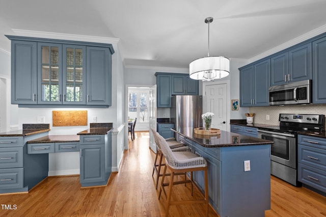 kitchen featuring blue cabinets, appliances with stainless steel finishes, and ornamental molding