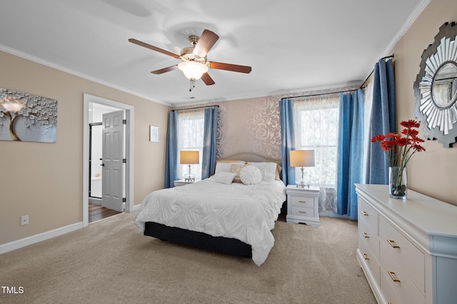 bedroom featuring ensuite bath, light colored carpet, baseboards, and ornamental molding