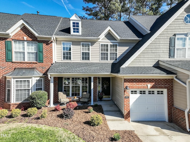 multi unit property with an attached garage, brick siding, concrete driveway, and roof with shingles