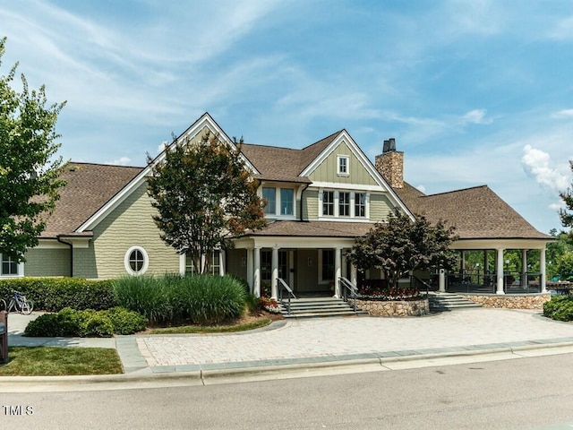 view of front of home with roof with shingles and a chimney