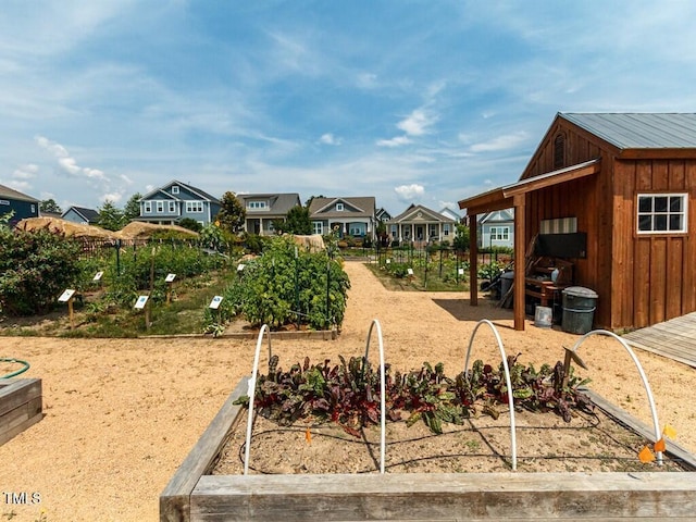 view of yard featuring a vegetable garden and a residential view