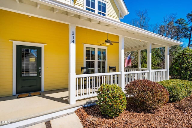 entrance to property with a porch and a ceiling fan