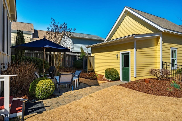 rear view of house featuring fence and a patio