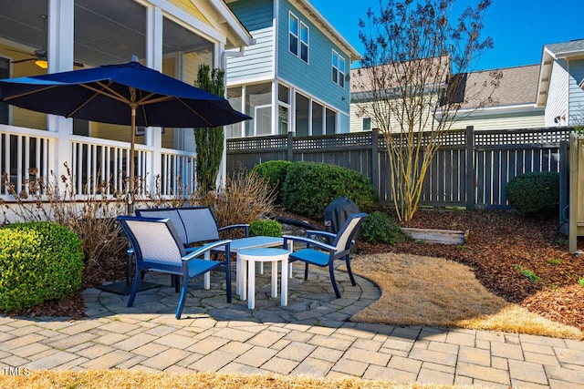 view of patio / terrace featuring a sunroom and fence