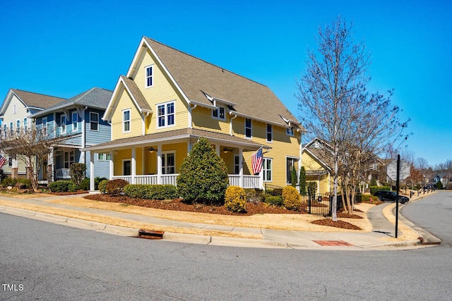 view of front of house with a shingled roof, a residential view, a porch, and a ceiling fan