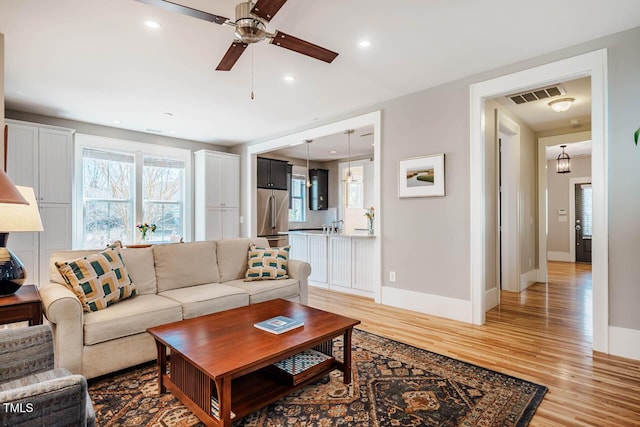 living area featuring light wood finished floors, baseboards, visible vents, and recessed lighting