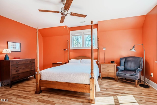 bedroom with a ceiling fan, baseboards, vaulted ceiling, and wood finished floors