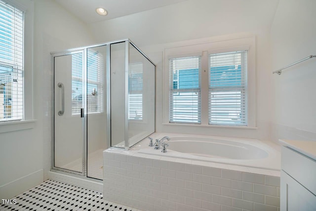 bathroom featuring a garden tub, vanity, a wealth of natural light, and a stall shower