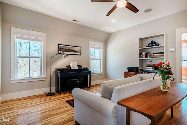 living area with light wood-style floors, visible vents, and baseboards