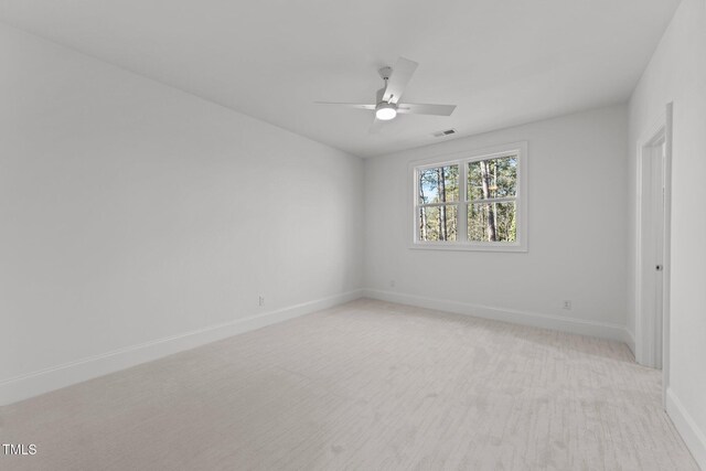 empty room with a ceiling fan, visible vents, and baseboards