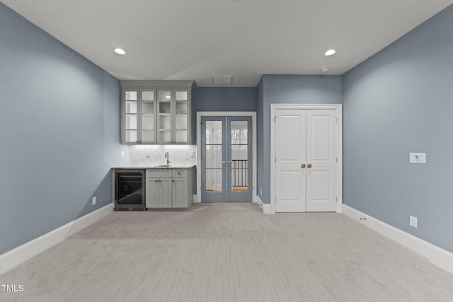 bar with french doors, wine cooler, indoor wet bar, and baseboards