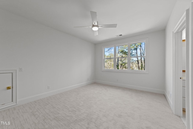 empty room featuring ceiling fan, visible vents, baseboards, and light colored carpet