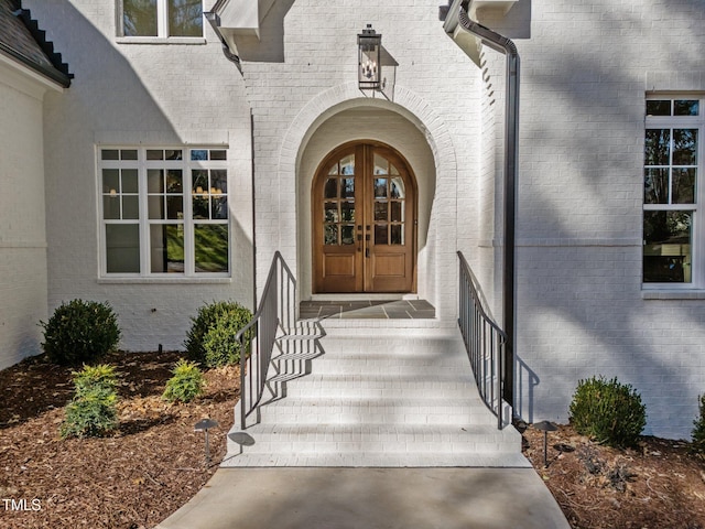 view of exterior entry with french doors and brick siding