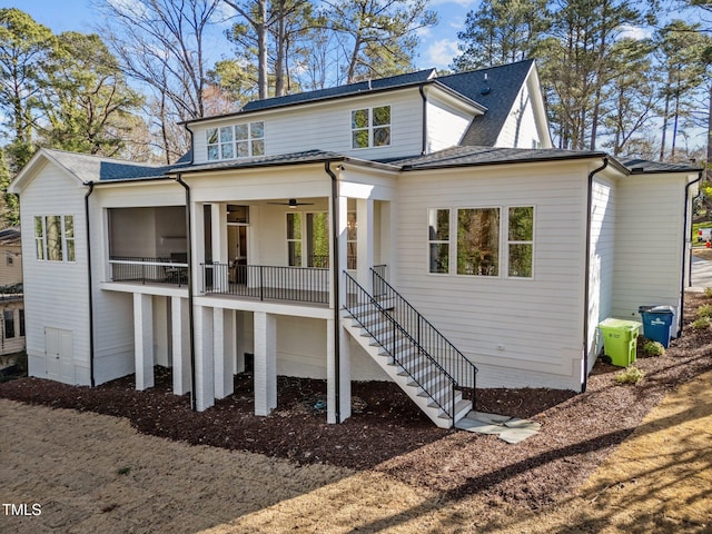 view of front of property with roof with shingles and stairway