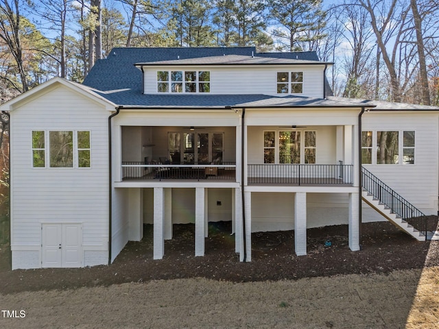 rear view of property featuring a shingled roof, stairs, and a ceiling fan