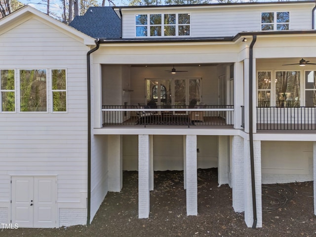 rear view of property with a sunroom, roof with shingles, and ceiling fan