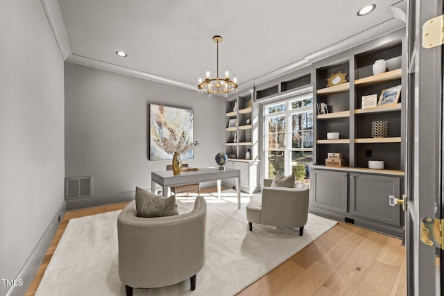 office space with ornamental molding, light wood-type flooring, visible vents, and a notable chandelier