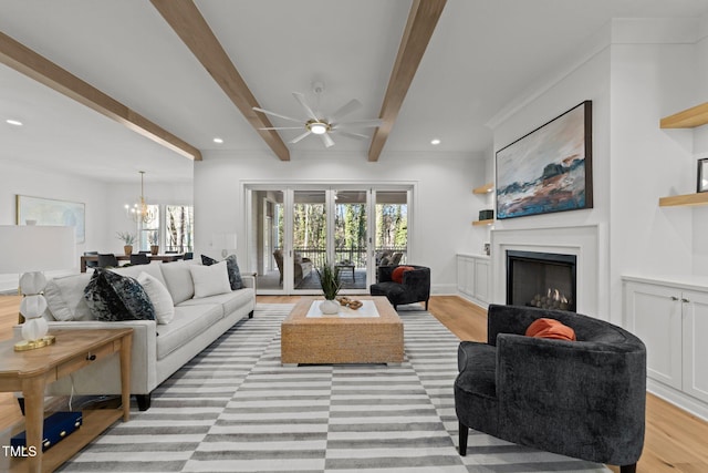 living area featuring light wood-style floors, recessed lighting, beam ceiling, and a fireplace