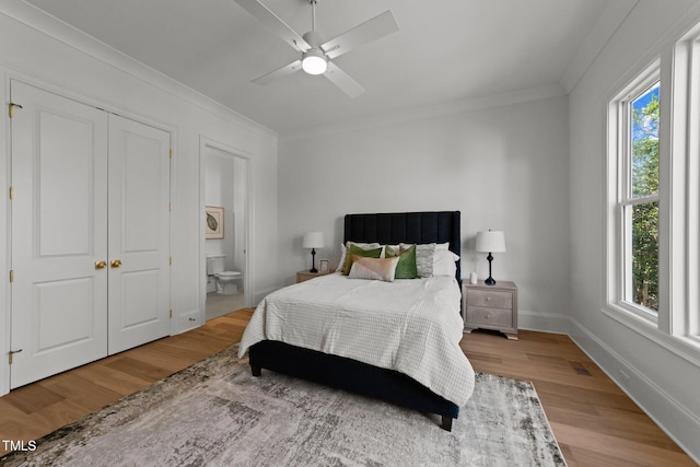 bedroom with light wood-style floors, multiple windows, and crown molding