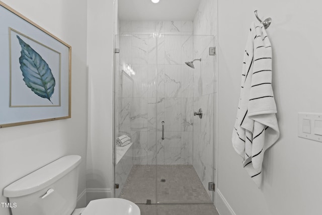 bathroom with a marble finish shower, toilet, and baseboards