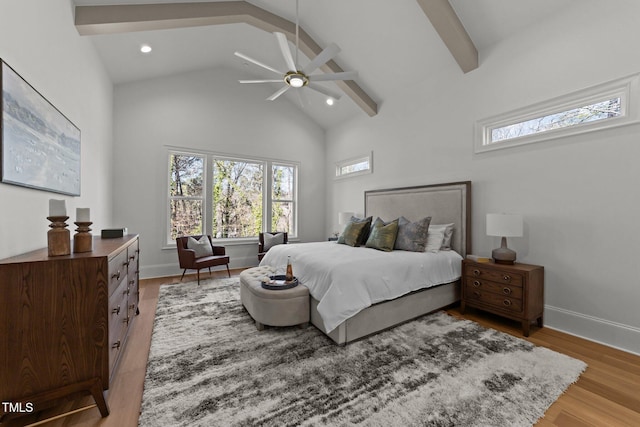 bedroom featuring high vaulted ceiling, beamed ceiling, light wood-style flooring, and baseboards